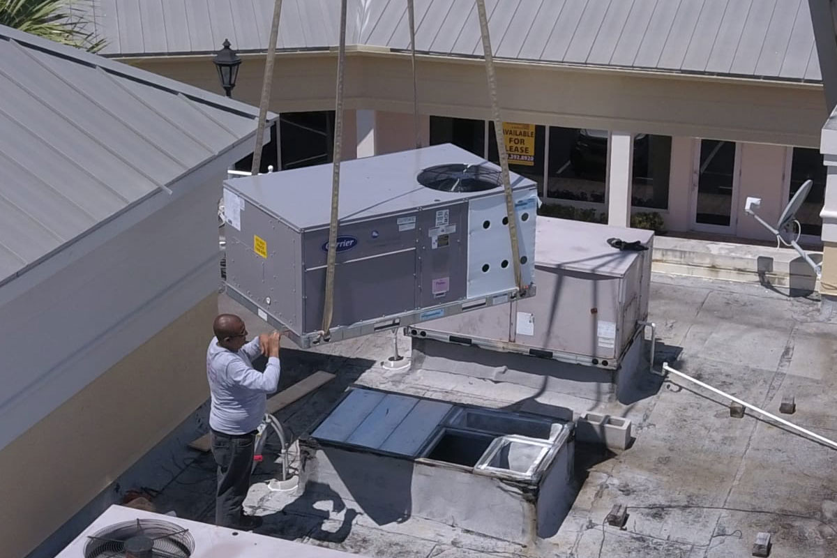 Air conditioning refrigeration system repair at a fast food establishment, featuring a crane lifting equipment to the rooftop. Santos Technical Services provides expert maintenance and repair for commercial HVAC systems, ensuring optimal performance for businesses in Boca Raton, Florida.