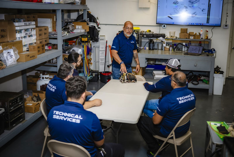 Santos Technical Services technicians in a training lab, enhancing skills in commercial kitchen maintenance and repair, specializing in coffee machines, refrigeration systems, and ice equipment. Expert team serving businesses in Boca Raton, Florida.