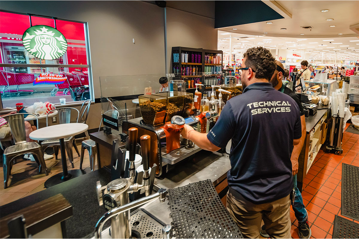 Santos Technical Services technician repairing a coffee machine at a Starbucks location, ensuring optimal performance and reliability for commercial kitchen equipment in Boca Raton, Florida.