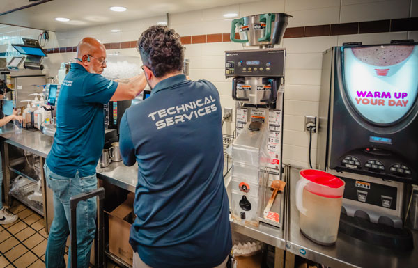 Two Santos Technical Services technicians repairing equipment at a Dunkin' Donuts location, providing expert maintenance for commercial kitchen machinery in Boca Raton, Florida.